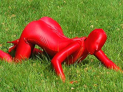 Flexible bitch with big jugs strips her hot red latex suit in nature!